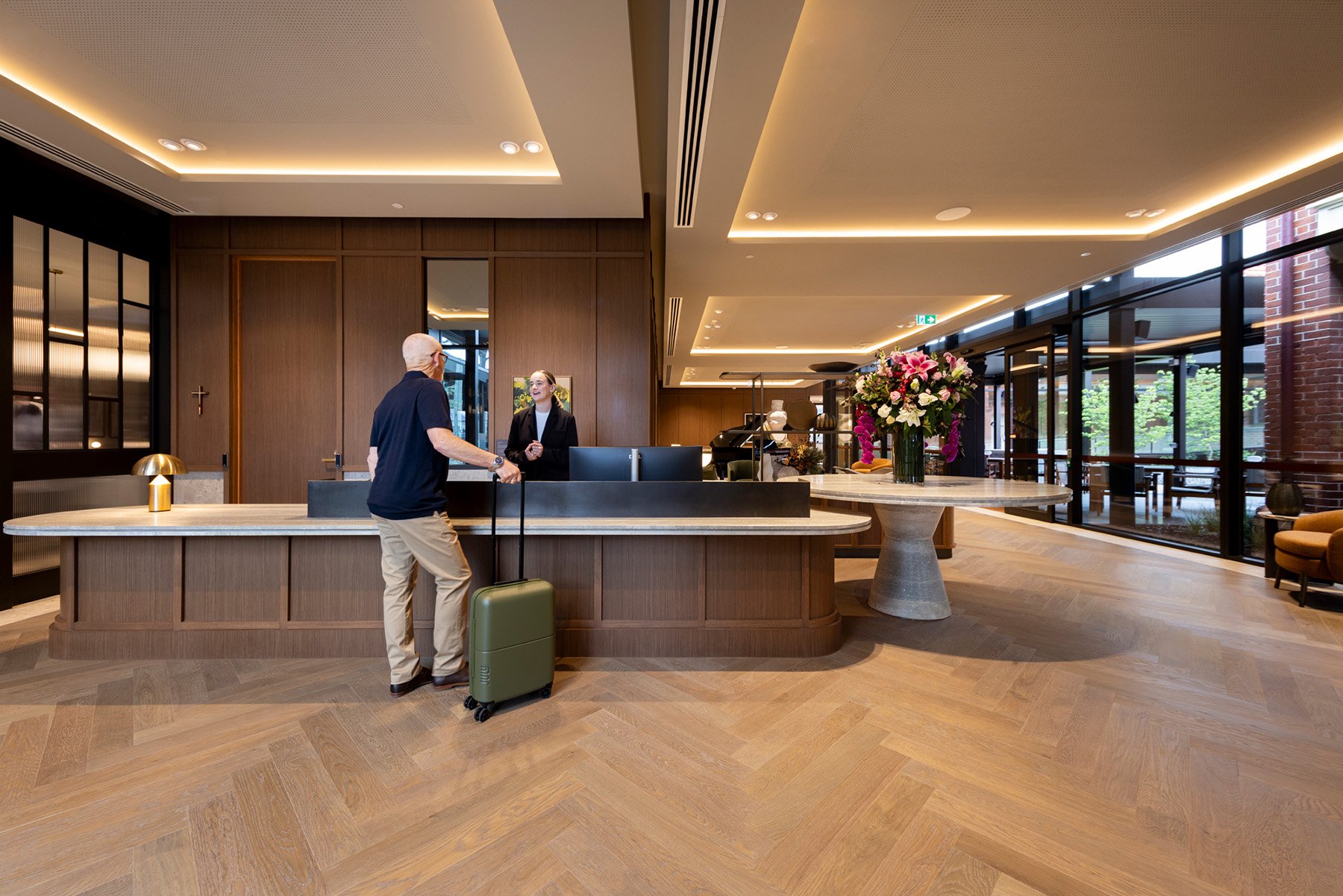 St. Clare resident with suitcase talking to Concierge