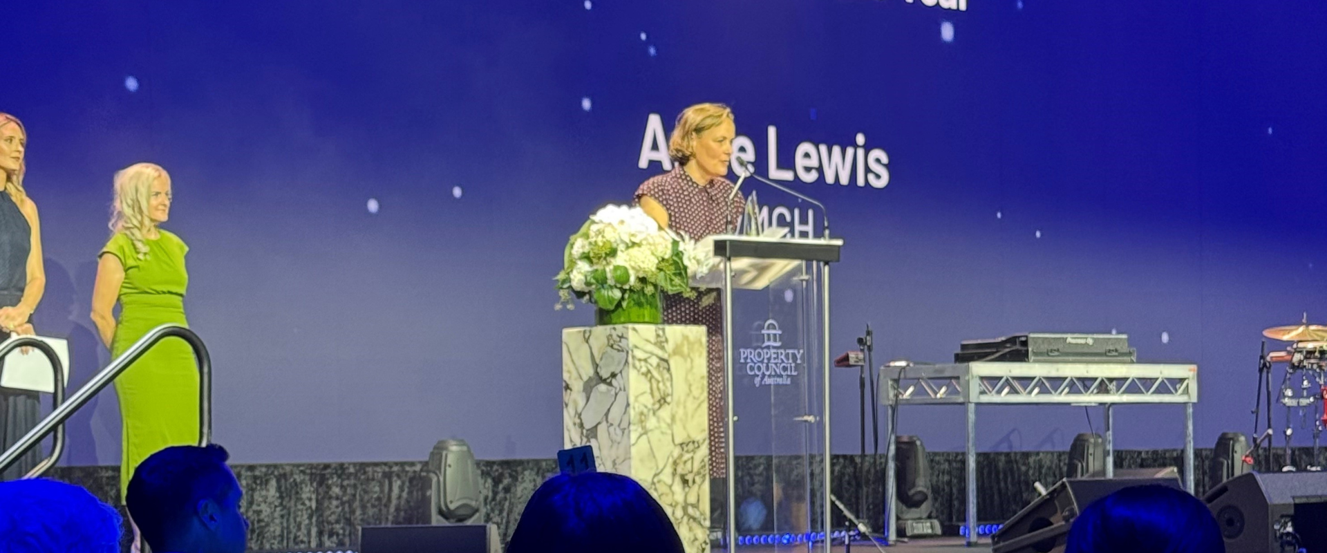 A woman stands at a podium making a speech